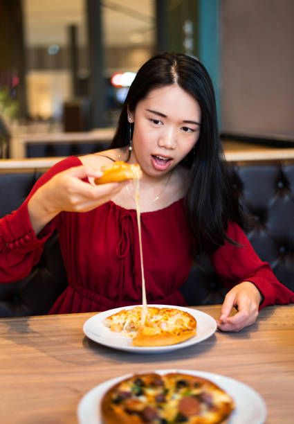 istock Girl eating pizza in the restaurant 1129341868