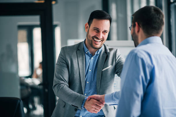 Portrait of cheerful young manager handshake with new employee. Portrait of cheerful young manager handshake with new employee. partnership stock pictures, royalty-free photos & images
