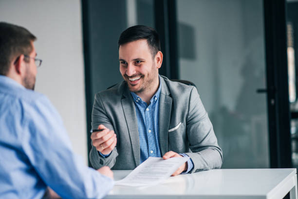 istock Smiling businessman giving pen to a client for signing a contract. 1129342465