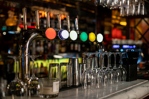 Close-up of a row of beer taps on a bar counter in a restaurant.