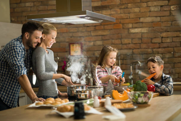 istock Happy family making lunch in the kitchen. 1129343530