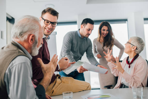 istock Young man sharing office with coworkers 1129343843