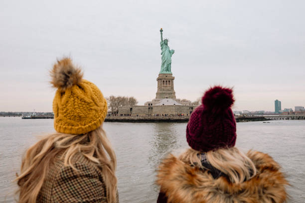 Viewing the Statue of Liberty Two women viewing the Statue of Liberty from a tour boat in New York City. american tourism stock pictures, royalty-free photos & images