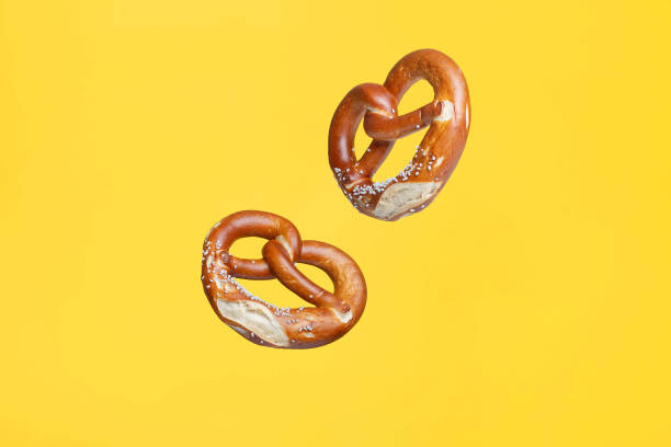 Flying Food Concept German Traditional Salted Pretzel on Yellow Background Flying Food Concept German Traditional Salted Pretzel on Yellow Background pretzel photos stock pictures, royalty-free photos & images
