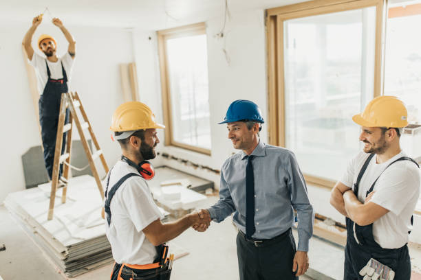 istock Happy construction workers came to an agreement with an architect during home renovation process. 1129346430
