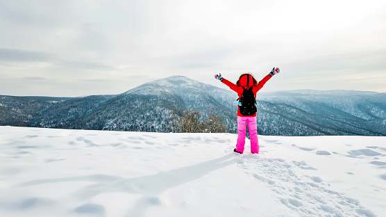Woman hiker on mountain top in winter.