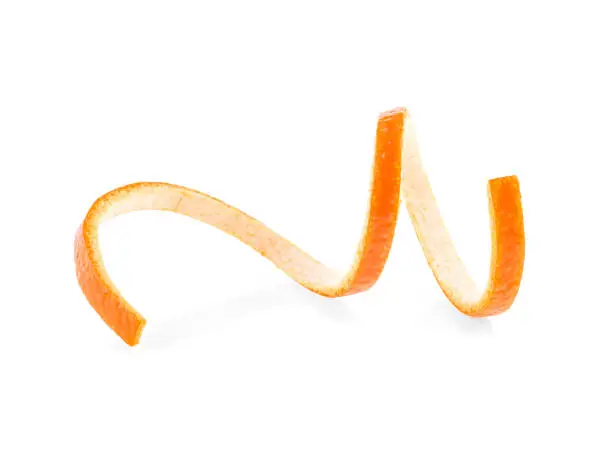 Photo of Twisted orange skin on a white background. Orange zest spiral.