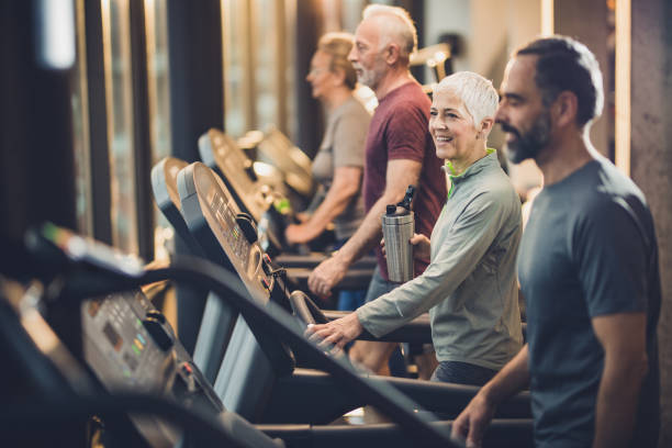 istock Group of athletic mature people practicing on treadmills in a gym. 1129350496
