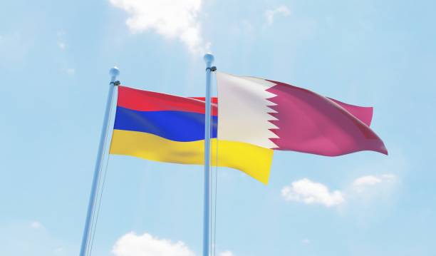 istock Qatar and Armenia, two flags waving against blue sky 1129351359
