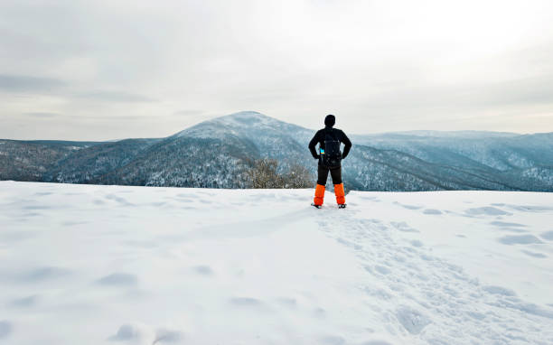 istock Man hiker on mountain top in winter 1129352091