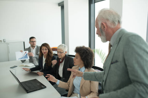 istock Business man looking at coworkers 1129352134