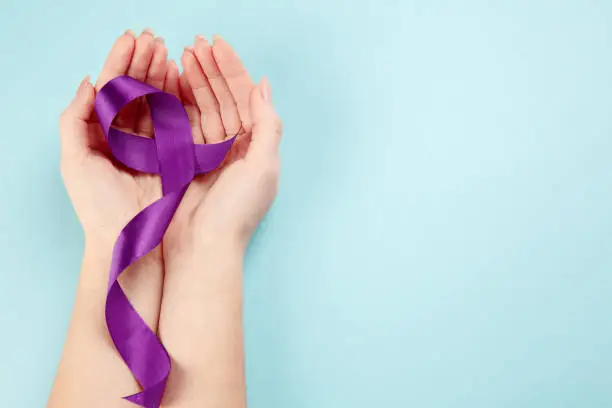 International or world Epilepsy Day concept. The text and a purple ribbon with female hands on a white wooden table background. The health, breast, awareness, campaign, disease, help, care, support, hope, illness, survivor, healthcare concept