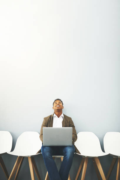 Almost time to go in now Studio shot of a young businessman using a laptop while waiting against a gray background its almost time stock pictures, royalty-free photos & images