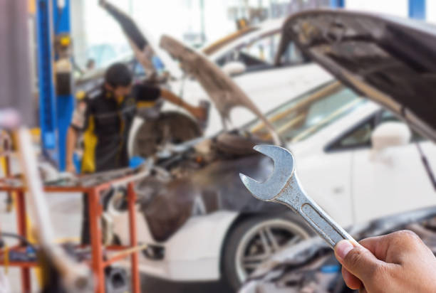istock car mechanic with wrench in garage. 1129356424