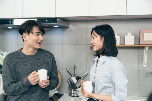 istock young chinese couple in kitchen 1129358883