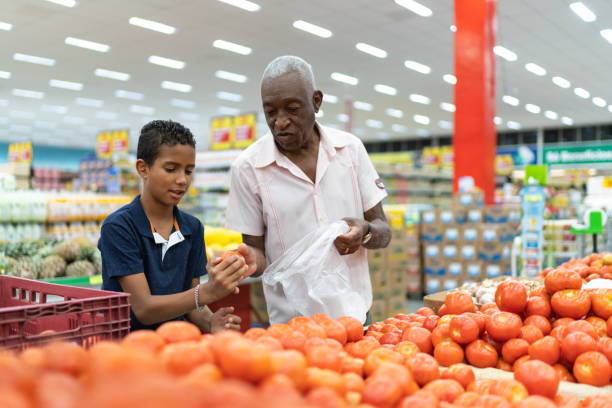 Afro latinx grandfather and grandson choosing orange at grocery store Family on Supermarket afro latinx ethnicity stock pictures, royalty-free photos & images