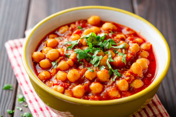 istock Spicy Chickpea curry Chana Masala in bowl on dark wooden table 1129362247