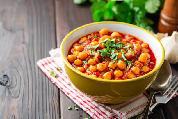 istock Spicy Chickpea curry Chana Masala in bowl on dark wooden table 1129362282