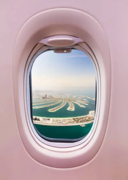 Airplane interior with window view of Dubai city, UAE. Concept of travel and air transportation