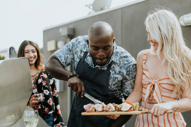istock Happy friends grilling barbeque at a rooftop party 1129367447