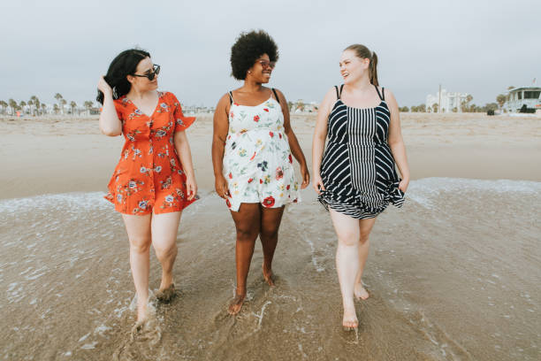 istock Curvy women at the beach 1129368044