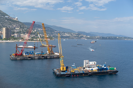 A construction crane barges begins land reclamation work off the coast of Monaco