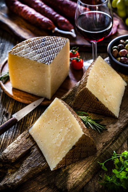 istock Spanish food: Manchego cheese, spanish chorizo, red wine and olives on rustic wooden table 1129369452