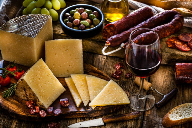 istock Spanish food: Manchego cheese, spanish chorizo and red wine on rustic wooden table 1129369492