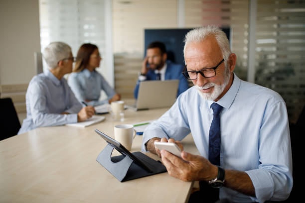 istock Senior businessman using mobile in the office 1129369594