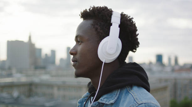 istock Young man listening music on a rooftop 1129370333