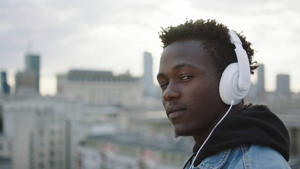 istock Young man listening music on a rooftop 1129370357