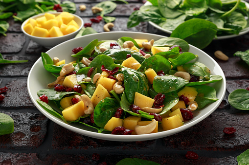 Mango Spinach salad with dried cranberries and nuts. healthy food
