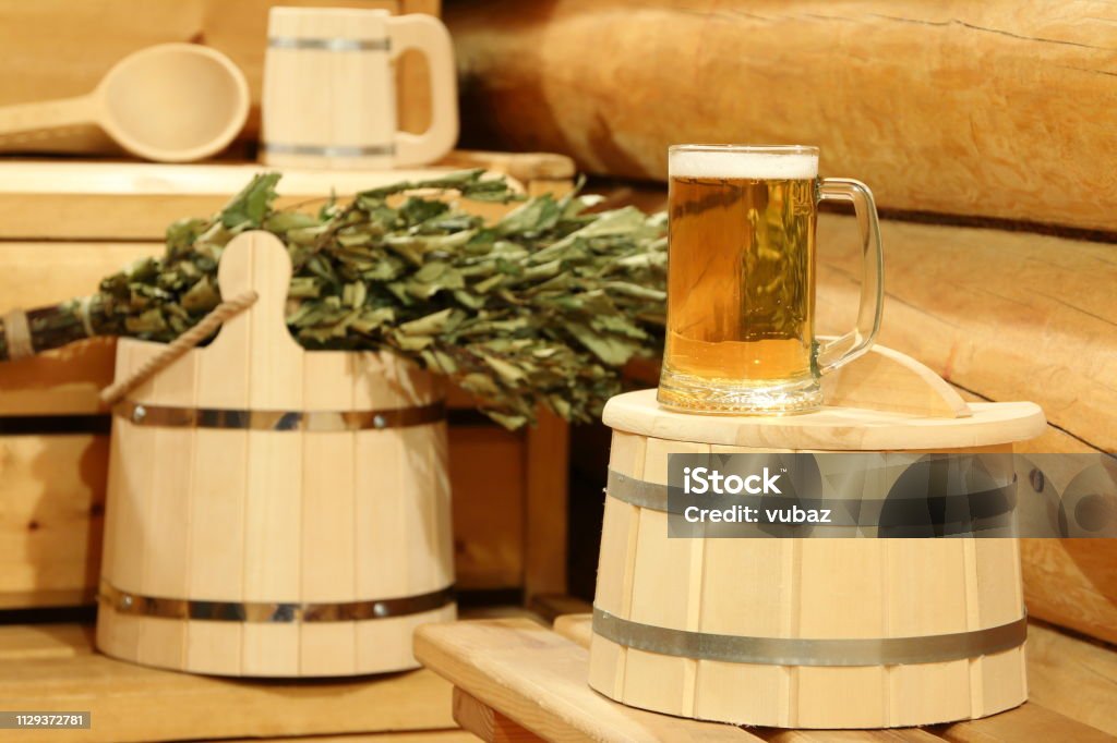 A mug of  light beer in the sauna. A mug of  light beer on a barrel in the interior of sauna on the background of bath accessories. Sauna Stock Photo