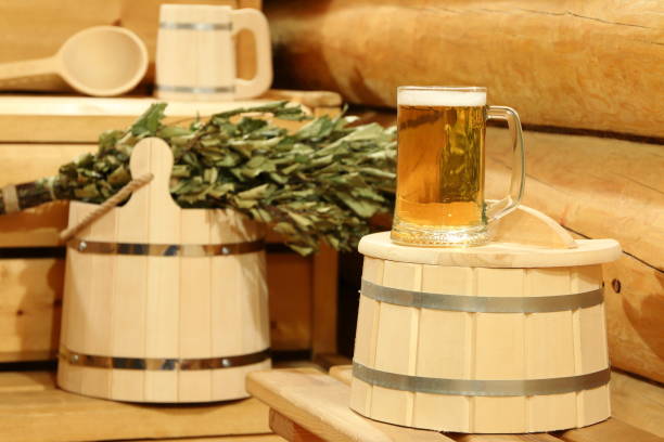 A mug of  light beer in the sauna. A mug of  light beer on a barrel in the interior of sauna on the background of bath accessories. красота stock pictures, royalty-free photos & images