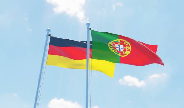 istock Portugal and Germany, two flags waving against blue sky 1129374503