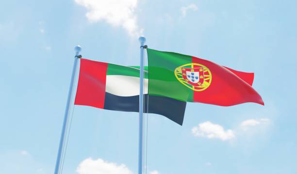 istock Portugal and UAE, two flags waving against blue sky 1129374706