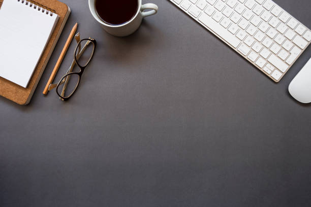 istock Home office desk over glasses, keyboard, mouse, pencil, notepad and coffee 1129377342