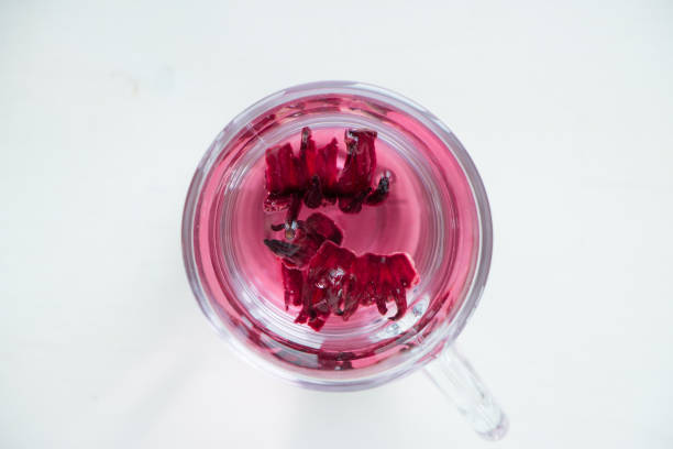 istock Red carcade tea in transparent glass cup at white wooden background 1129377904