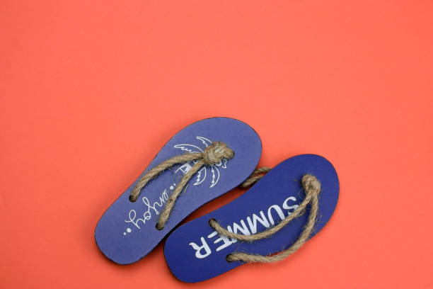 istock wooden flip flops on a coral background copy space 1129380602