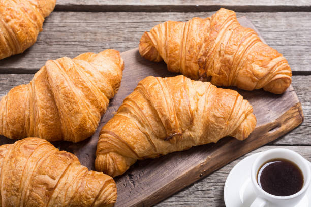 istock Croissants on wooden background 1129381562
