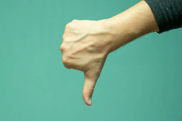 istock man's hand with a gesture showing disapproval, thumb down 1129382947