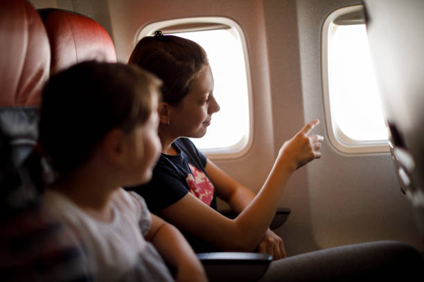niños mirando el cielo a través de la ventana de avión - looking at view watching pointing showing fotografías e imágenes de stock