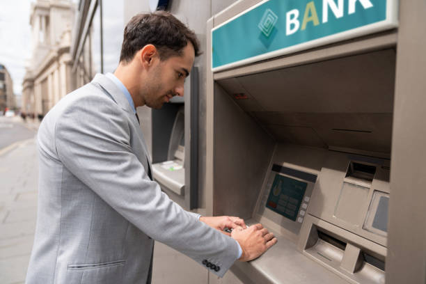 istock Business man making a cash withdrawal at an ATM 1129386376