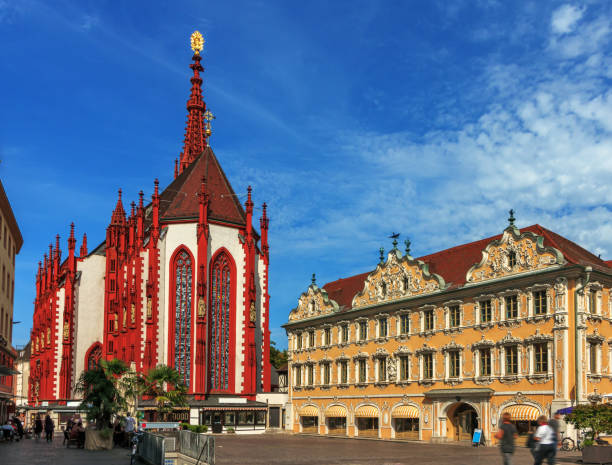 A roman catholic cathedral in a gothic style and a falkenhaus in Wurzburg in the morning