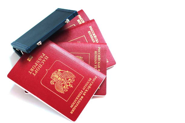 der pass der russischen föderation. biometrischen russische pässe sind aying um einen miniatur-koffer auf einem weißen hintergrund. - customs official examining emigration and immigration document stock-fotos und bilder