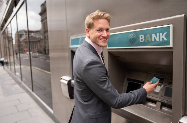 istock Business man making a cash withdrawal at an ATM 1129388603