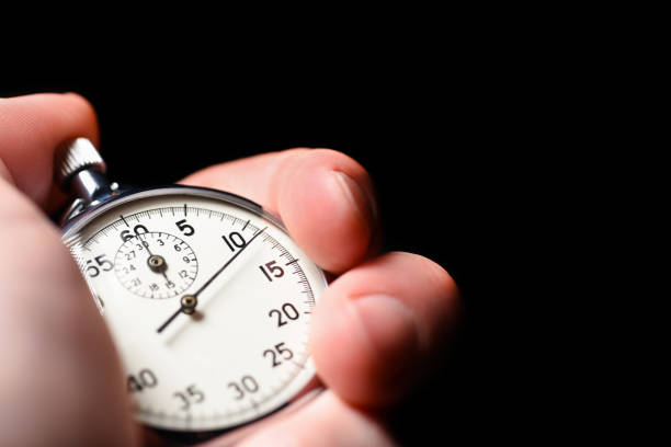 istock Male hand starts the analog stopwatch on a black background, close-up, isolate, copy space 1129390131