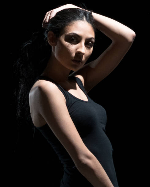 istock Beautiful female standing in the dark 1129391262