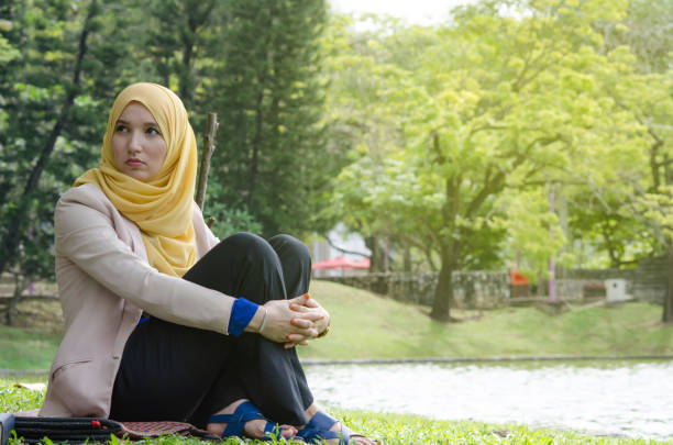 istock Thoughtful Woman Wearing Hijab While Sitting At Park 1129394984