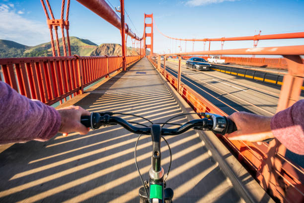 Crossing the Golden Gate Bridge by bike A personal perspective of a biker crossing the iconic Golden Gate Bridge in San Francisco, California, as cars cross the bridge in the distance. golden gate bridge stock pictures, royalty-free photos & images